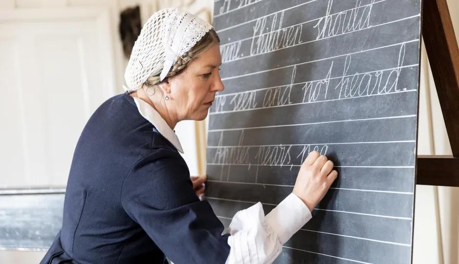 Woman writing on chalk board