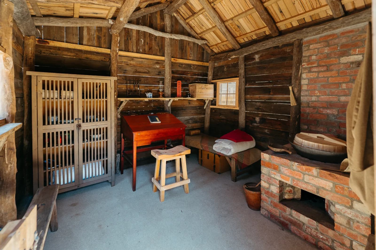 Interior of a historical cabin or dwelling, showcasing period-appropriate furnishings and decor.