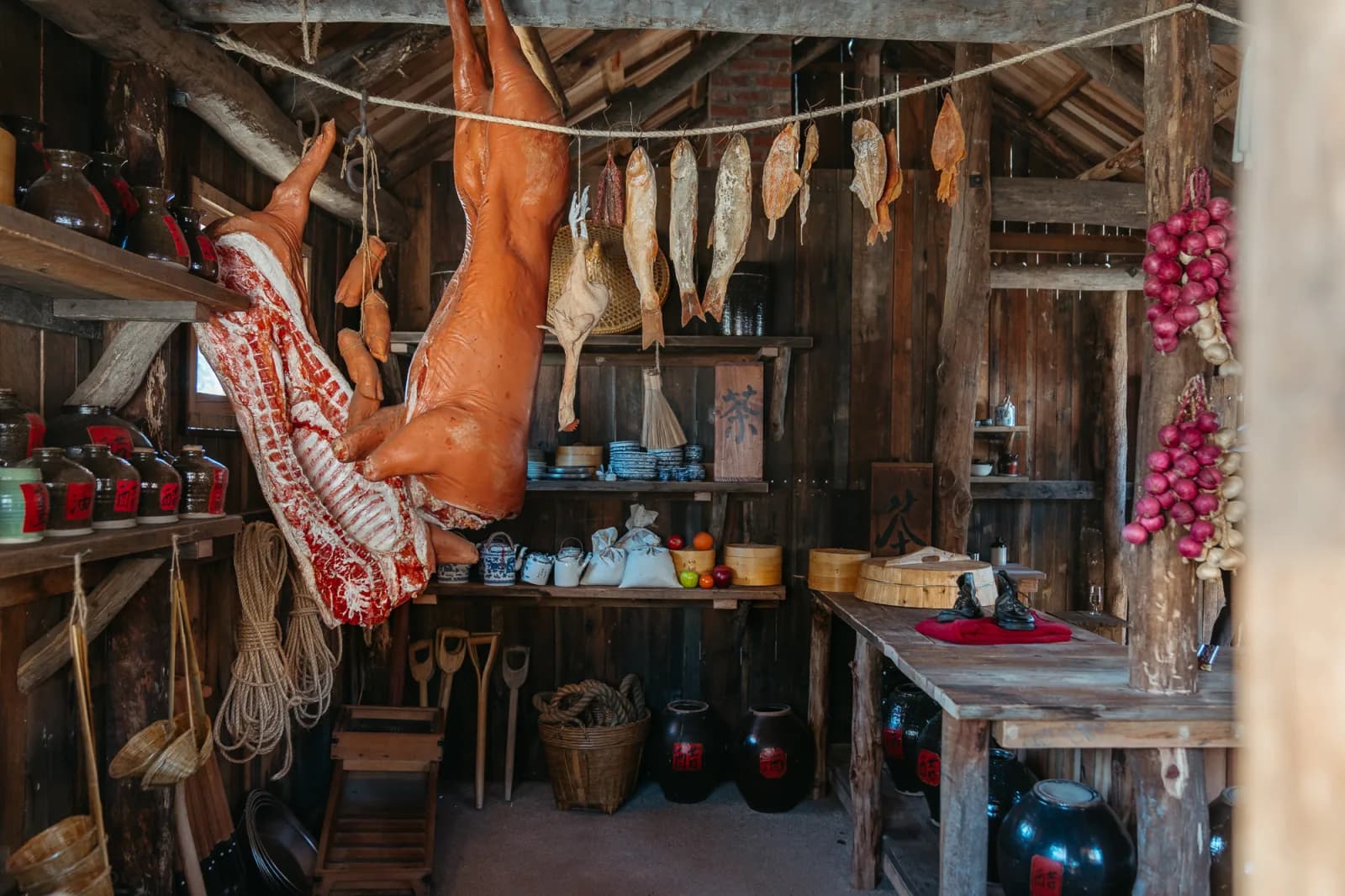 Interior of a historical building showcasing traditional food preservation methods, including dried meats and preserved vegetables.