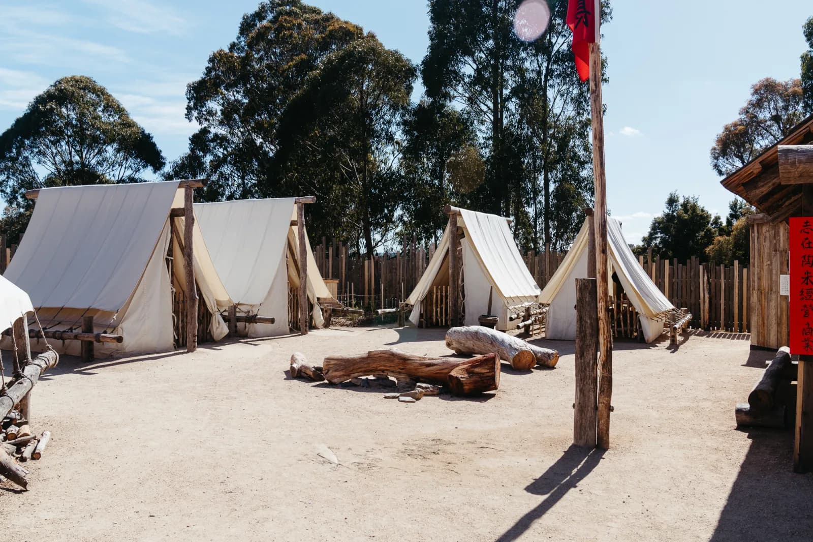 Recreation of a historical campsite, featuring tents, wooden structures, and period-appropriate furnishings.