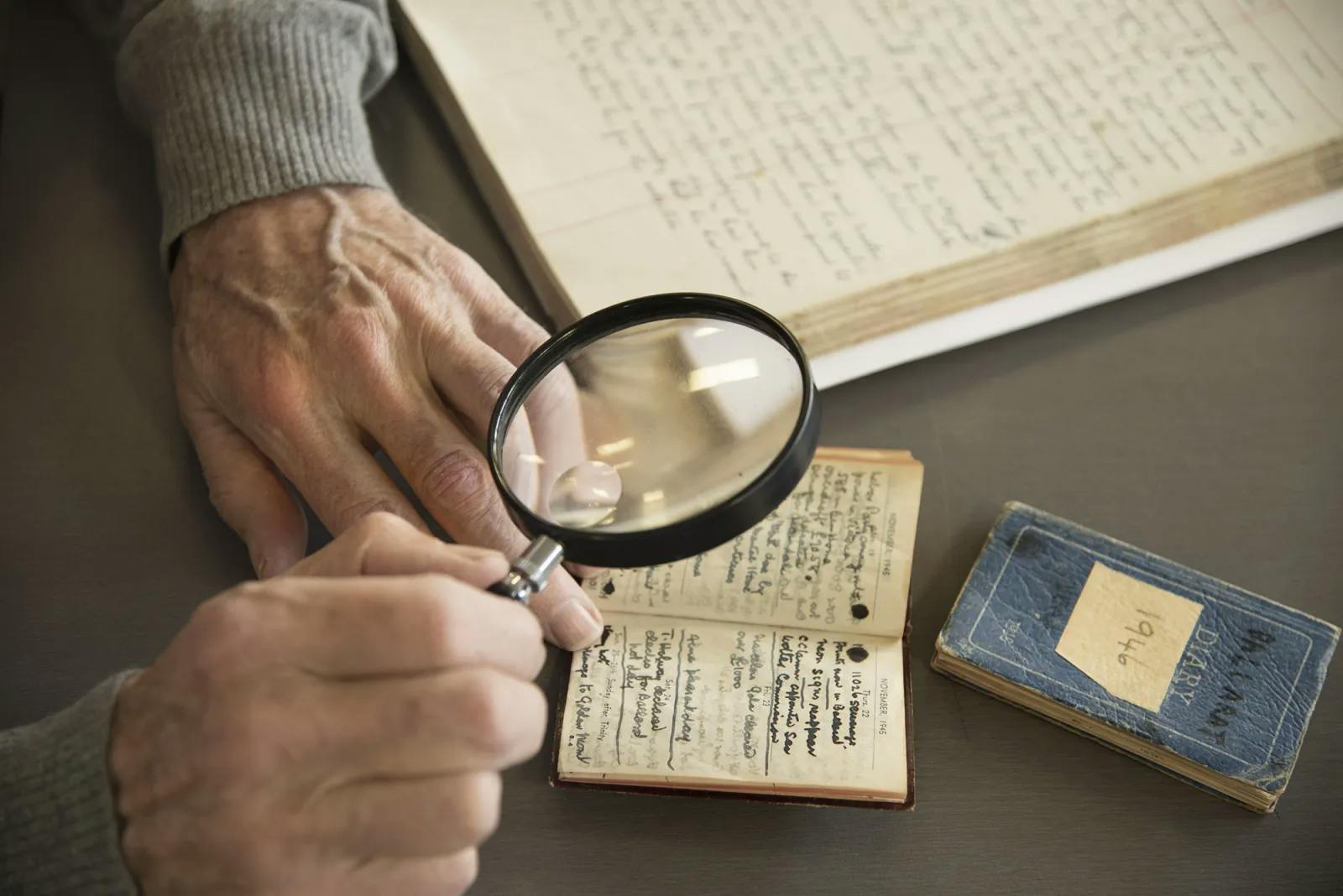 Man with magnifying glass looking at diary