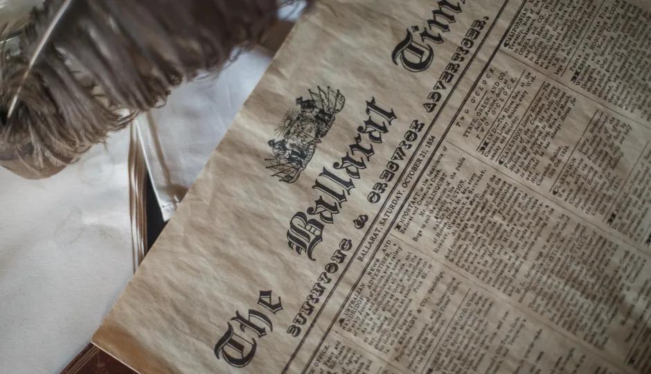 Student reading a replica 1854 Ballarat Times newspaper as part of Sovereign Hill’s historical learning resources.
