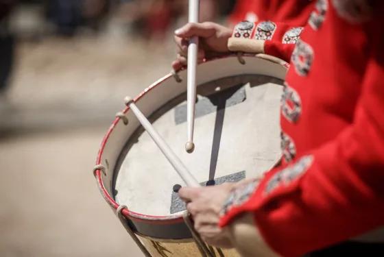 Close-up of a costumed performer playing a traditional drum during a historical celebration at Sovereign Hill.
